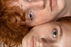 Image two people with red hair and freckles looking into camera - close up of faces