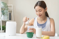 smile asian young woman, girl in sportswear, hand in holding scoop making protein shake