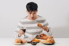 Asian man eating unhealthy