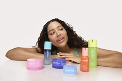 Image A girl with beauty products in front of her on a table.