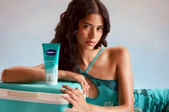 Image Woman in blue posing by tube of skin cream