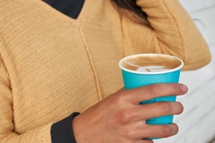 Woman holds paper coffe cup