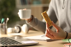 Image Eating protein bar while working.
