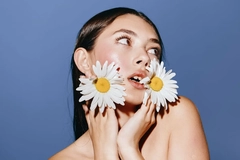 Image Woman with flowers in her hair against blue backdrop