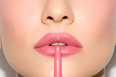 Image A woman putting on lip liner.