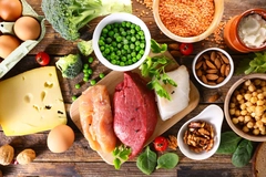 Image High protein food sources, raw meat, fish, eggs, legumes and nuts on wooden background.