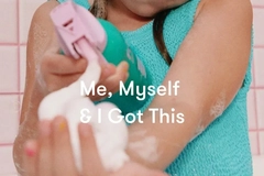 Image A little girl putting soap into her hand.