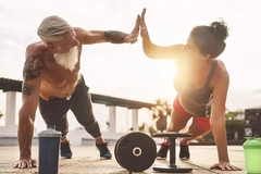 Athletes high-fiving during strength training with weights