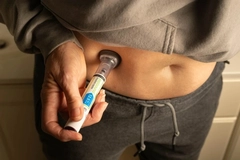 Image Person using a GLP-1 medication by injecting into their stomach area.