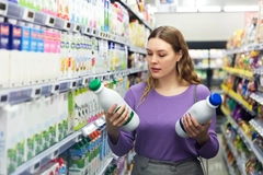 Image Woman holding milk bottles.