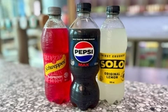 Image three bottles of soft drinks on a table