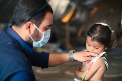 Image A doctor examines children's malnutrition inside a refugee camp