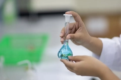 Image scientist holding blue flask of chemicals