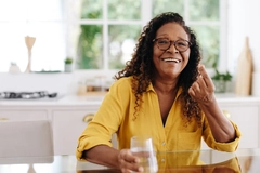 Image Woman taking nutrition supplements at home in kitchen