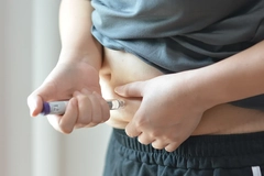 Image human injecting themselves in stomach with weight loss jab