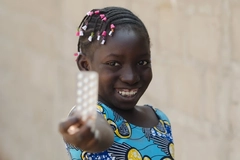 Little girl holding up zinc pills