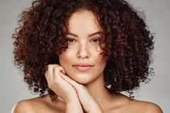 Woman with curly hair and a clean face with freckles