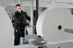 Image man rolling fiber based machine in factory