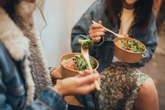 two women enjoying salad from bio-plastic takeaway bowl
