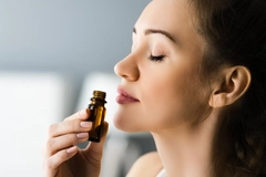 Image A woman smelling an essential oil.