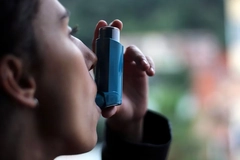 Image woman using inhaler for asthma attack