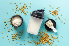 Image An image with a protein shaker and legumes on blue background