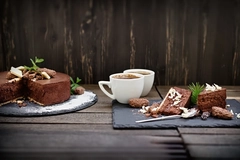 Image Baked goods and hot chocolate drinks on a table outside.