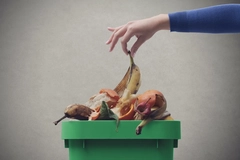 Image Woman putting organic waste in the recycling bin