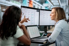 Image Two women evaluating the LCAs of products on two large computer screens.