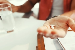 woman holding pills in her hand for clinical trial
