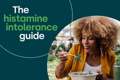 Image Histamine intolerance guide graphic featuring a woman eating a bowl of leafy greens outdoors.