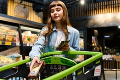 Image Young woman shops for food in the supermarket.