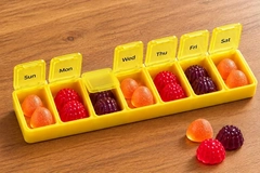 Image Colorful Gummies in a medicine box divided by days