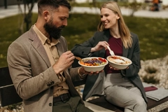 Image Two people eat from bio-based foodservice packaging