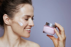 Image A woman holding a pot of skin cream.