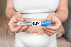 Image GLP-1 injection pen in female hands near abdomen.