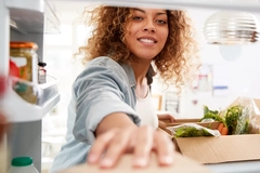 Image a woman opening a fridge