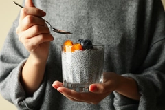 Image Woman holding a dessert in a glass.
