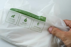 Image Hand holding eco friendly biodegradable plastic bag with sustainability labels