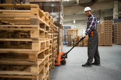 Image man pushing pallets around in warehouse