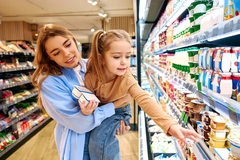 Image Woman and child in supermarket, looking at products.