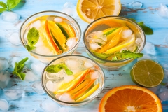 Three beverages with mint leaves and lemon slices, refreshing and vibrant.