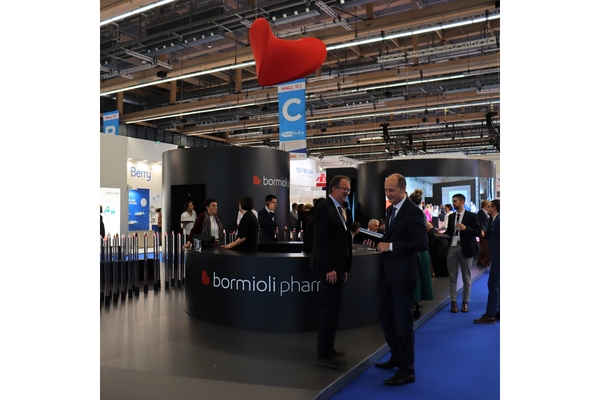 Trade show booth with Bormioli Pharma signage and attendees