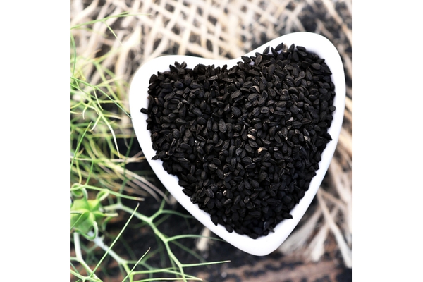 Image Trinutra's cold-pressed black seed in a heart shaped bowl.
