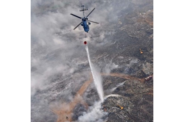 Image Naval helicopter drops water on Brahmapuram waste dump fire