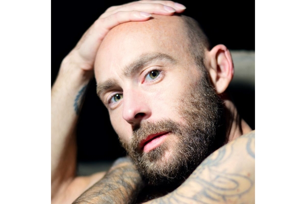 Image bald man posing with hand on head.