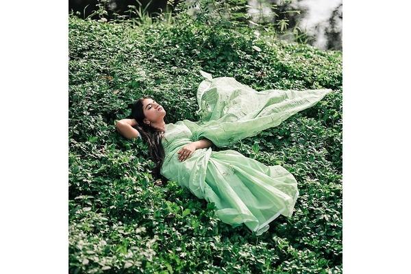 Woman in sari laying on lush green plants