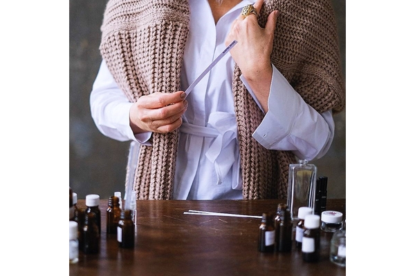woman testing fragrance oils with paper strips.