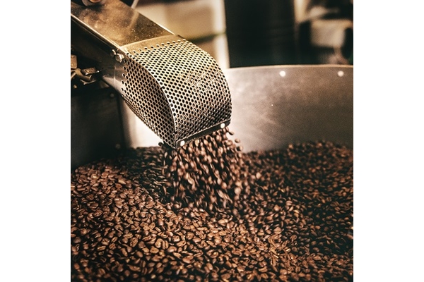Image Coffee beans falling into a roaster.