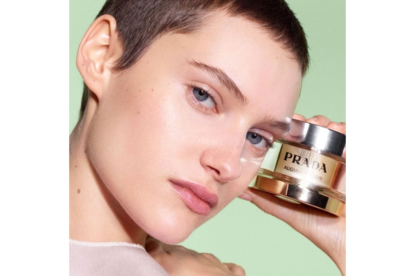 Image A female model holds up a jar of Prada's new skin cream from the brand Prada Skin.